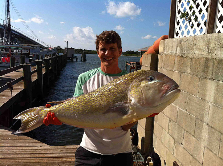 Kelly holding up a Golden tilefish on a dock