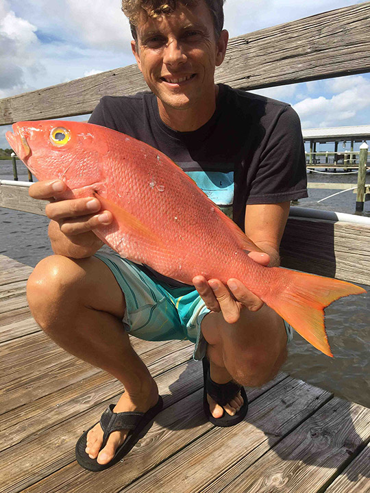 Kelly kneeling with a small yelloweye snapper